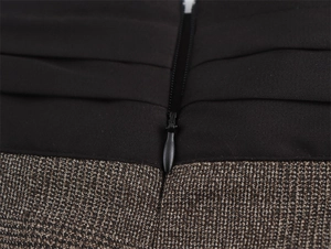 Dettaglio del tessuto patchwork a contrasto con trama a pieghe e zip nera invisibile