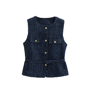 Detail der marineblauen Strickweste mit Goldfäden und verzierten goldenen Knöpfen