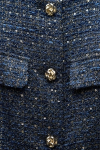 Detailansicht der dunkelblauen Tweed-Strickweste mit Goldfäden und strukturierten Knöpfen