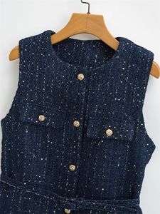 Nahaufnahme der dunkelblauen Tweed-Weste mit goldenen Pailletten und verzierten Knöpfen