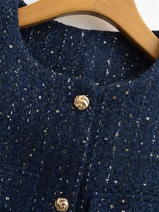 Detail der marineblauen Tweed-Weste mit Goldpailletten und verzierten Metallknöpfen