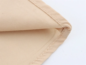 Detailopname van stevige canvas stiksels en fijne stoftextuur op de jurk met V-hals