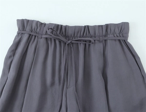 Detail der High-Waist-Paperbag-Hose in Dunkelgrau mit passender Schleife am Gürtel