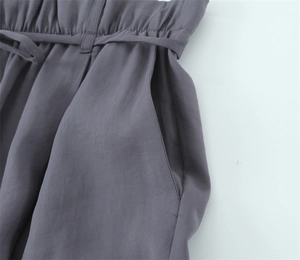 Nahaufnahme der dunkelgrauen High-Waist-Hose mit Faltenwurf und passendem Gürtel