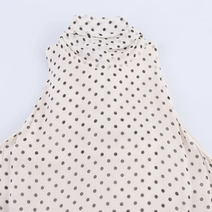 Close-up of mock neck detail on polka dot chiffon dress with lightweight texture