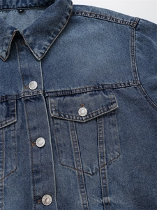 Detailansicht der blauen Jeansjacke mit Kragen, Brusttasche und Silberknöpfen