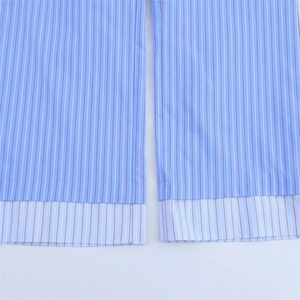 Detail of light blue striped cotton fabric with double-layered hem and fine red vertical stripes