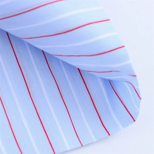 Macro shot of breathable blue cotton fabric with vibrant red and white stripes detail