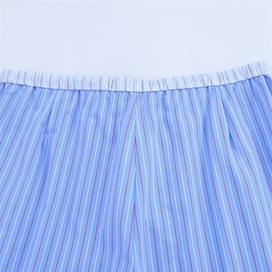 Detailed close-up of blue and white striped cotton fabric with elastic waistband detail