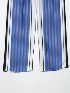 Détail du tissu à rayures verticales bleu et blanc sur un pantalon large décontracté