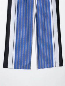 Détail des rayures verticales bleues et grises sur le tissu d'un pantalon d'été