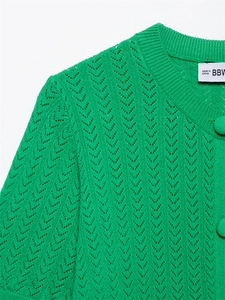 Detalle del top de punto verde esmeralda con escote acanalado y patrones calados en V