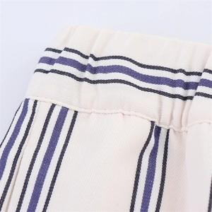 Dettaglio della vita elastica con strisce blu sul tessuto beige dei pantaloni larghi
