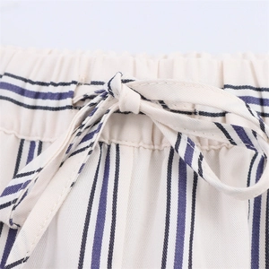 Dettaglio dell'elastico in vita con coulisse sui pantaloni a gamba larga a righe panna e blu
