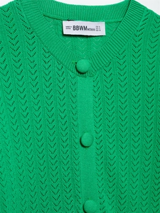 Detalle de cárdigan verde de punto calado con diseño de ondas y botones forrados