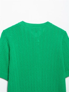 Primer plano del top de punto pointelle verde esmeralda con textura calada en forma de V