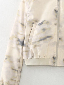 Detail of tie-dye jacket featuring metal zipper, side pockets and ribbed elastic hemline