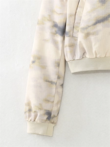 Detailed macro view of tie-dye fabric texture and ribbed cuffs on a casual jacket