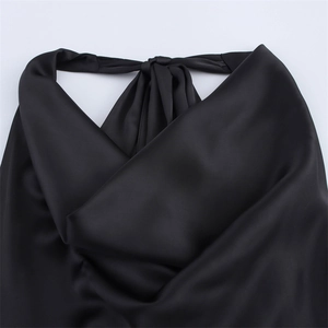 Detail eines schwarzen Satin-Halter-Tops mit seidiger Textur und elegantem Nackenband