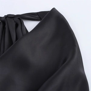 Detail eines schwarzen Satin-Neckholders mit Seidenbandschleife und elegantem Faltenwurf