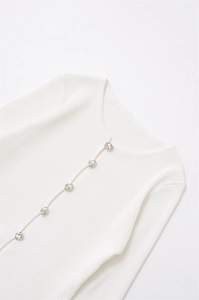 Detail of ribbed knit cardigan with irregular silver metal buttons and round neck