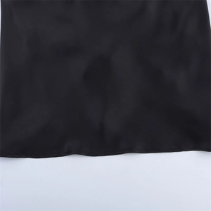 Detailansicht des glatten Saums dieses schwarzen Satinkleids mit seidiger Textur
