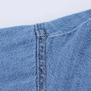 Close-up of double stitching and high-density denim fabric texture on blue jeans