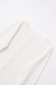 Close-up of white ribbed knit fabric texture and neckline detail on long sleeve top