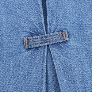 Detailed macro view of denim fabric texture with reinforced brown contrast stitching
