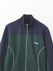 Détail de la veste de sport rétro montrant des panneaux vert et bleu marine