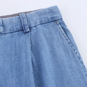 Detailed view of light blue denim jeans waist showing belt loops and pocket stitching
