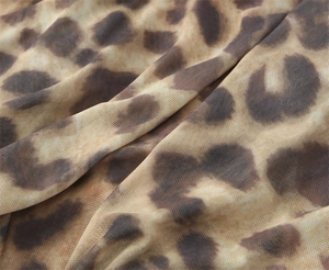 Vista macro de tela de malla con estampado de leopardo que muestra la textura y suavidad