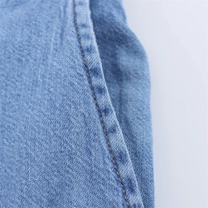 Detail shot of light blue denim fabric showing high-quality stitching and texture