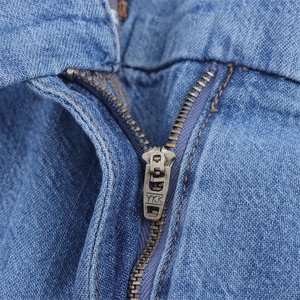 Macro shot of high-quality YKK metal zipper and blue denim twill texture details