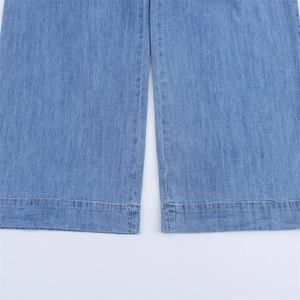 Detailed close-up of wide-leg denim jeans with durable orange double stitching at the hem