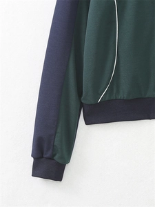 Détail des poignets côtelés sur une veste rétro vert foncé et bleu marine zippée