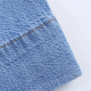 Close-up of blue denim fabric with visible twill texture and contrast yellow stitching