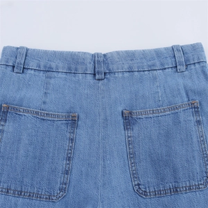 Detail view of light blue denim shorts featuring double-stitched back pockets and washed fabric