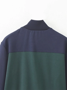 Détail de veste bicolore bleu marine et vert avec col montant côtelé et finitions soignées