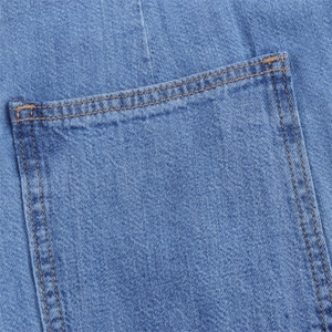 Macro shot of blue washed denim pocket with orange contrast stitching and twill texture