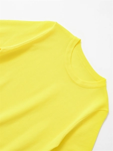 Détail du col rond côtelé et du tissu texturé de ce pull en tricot jaune vif à manches