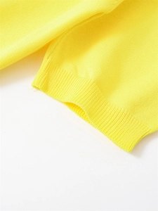 Détail de la maille jaune vif avec maille plate fine et finition des poignets côtelés