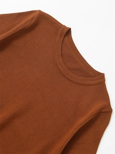 Gros plan détaillé sur la texture en maille marron foncé et le col rond du pull