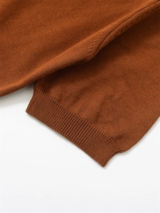 Détail des poignets côtelés et du motif en maille ajourée fine couleur caramel