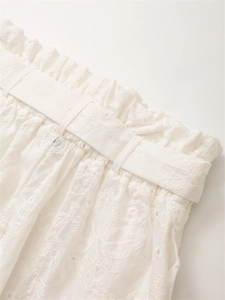 Dettaglio del ricamo floreale bianco e pizzo sangallo sui pantaloncini con elastico