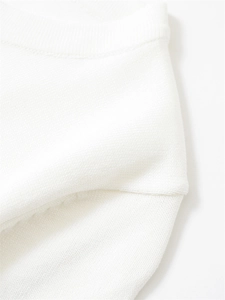 Gros plan sur la maille blanche montrant la texture alvéolée et les détails du col rond