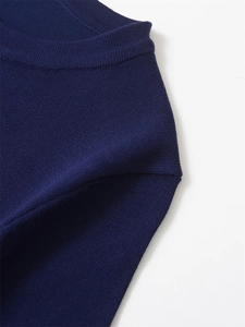 Détail de l'encolure ronde et de la texture en maille de ce haut bleu marine à manches