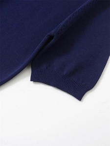 Gros plan détaillé d'un pull en maille bleu marine avec poignets côtelés et coutures fines