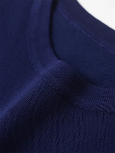Gros plan sur la maille fine et le col rond du pull bleu marine à manches courtes