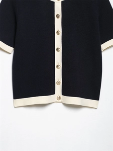 Close-up of contrast trim knit cardigan with gold anchor buttons and navy texture